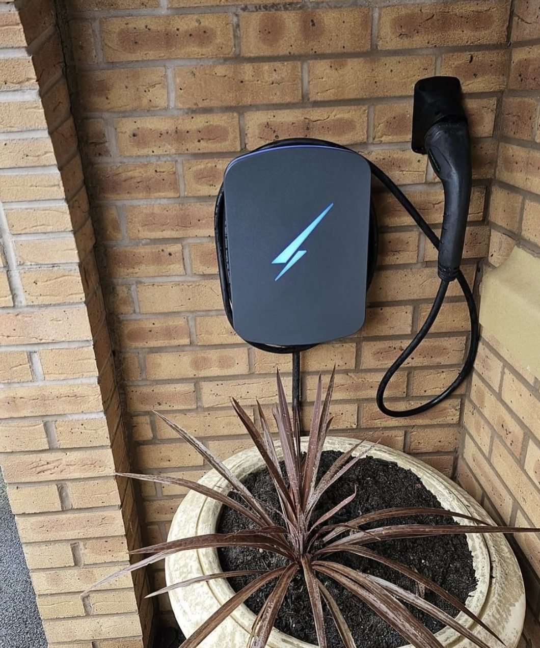 Tethered EV charge point mounted in a sheltered porch