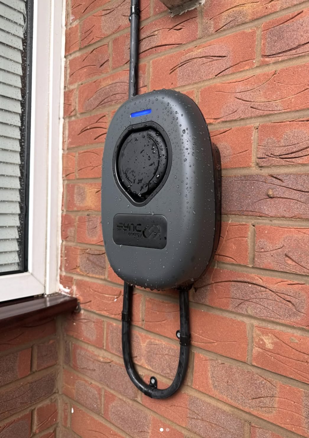 Weatherproof EV charge point installed on an exterior brick wall