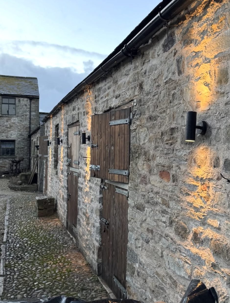 Up and down wall lights along a stone outbuilding